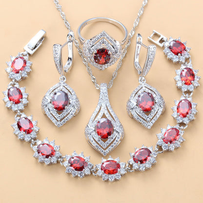 Jewelry set with red gemstones and silver accents on a beige background