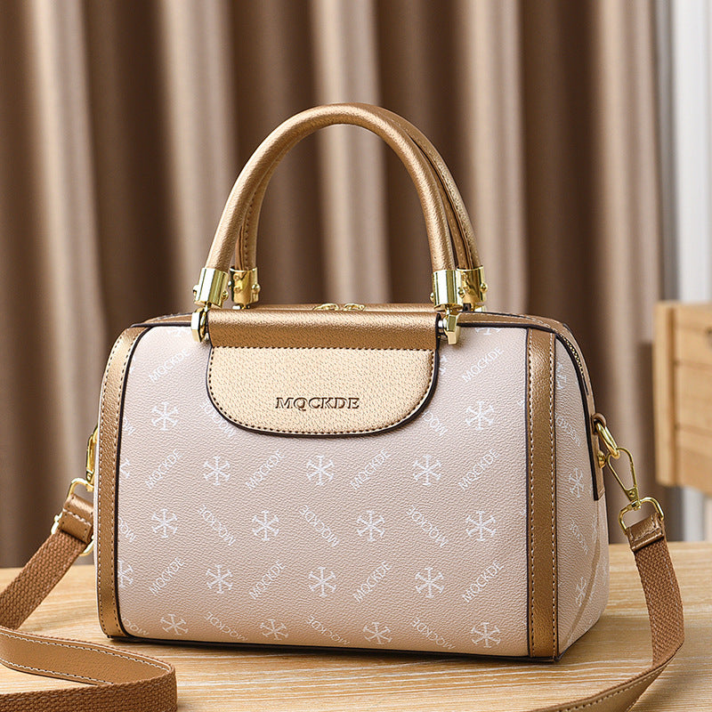 Beige handbag with gold accents on a wooden surface