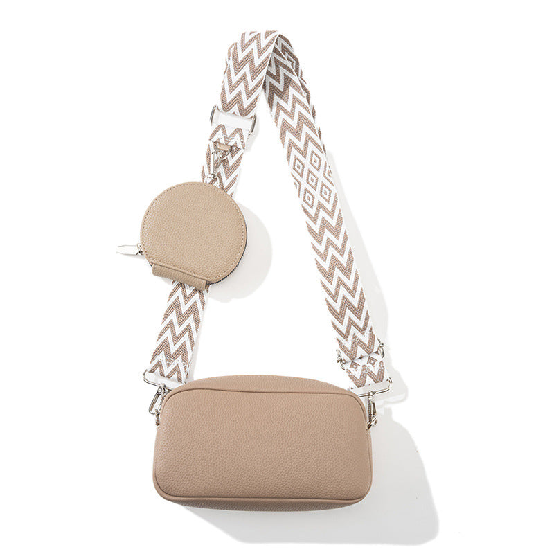 Beige handbag with a patterned strap on a white background