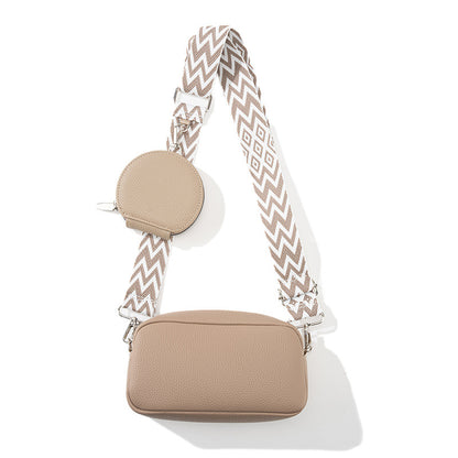 Beige handbag with a patterned strap on a white background