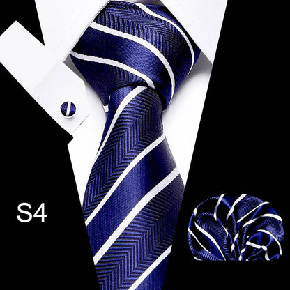 Navy blue tie with white stripes, cufflink, and pocket square on a black and white background.