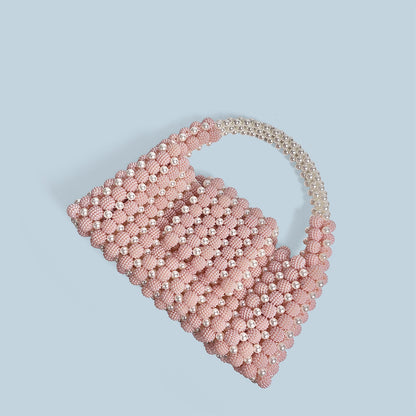 Pink beaded handbag with a chain handle on a light blue background