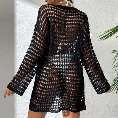 Black crochet dress worn by a person against a white wall.