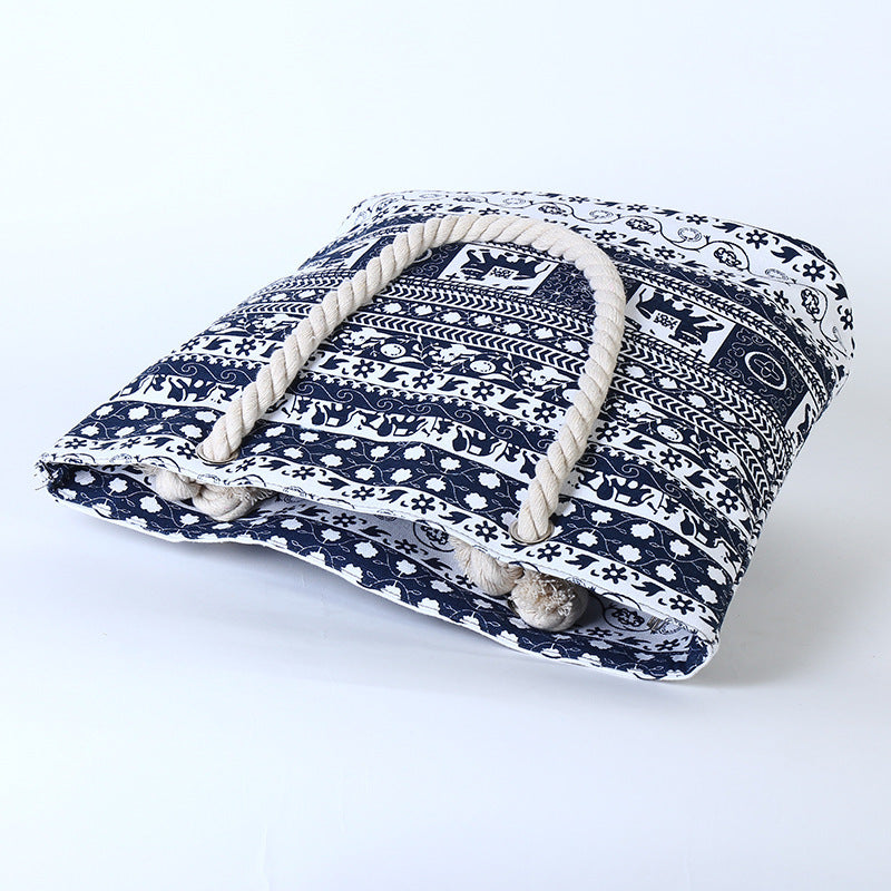 Navy blue and white patterned pet bed with rope handles on a white background
