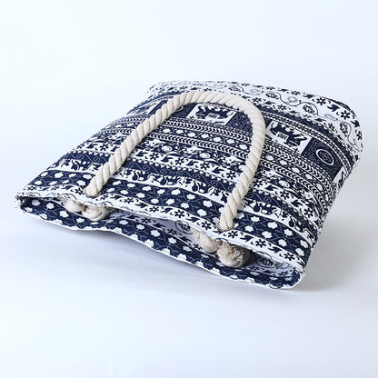 Navy blue and white patterned pet bed with rope handles on a white background