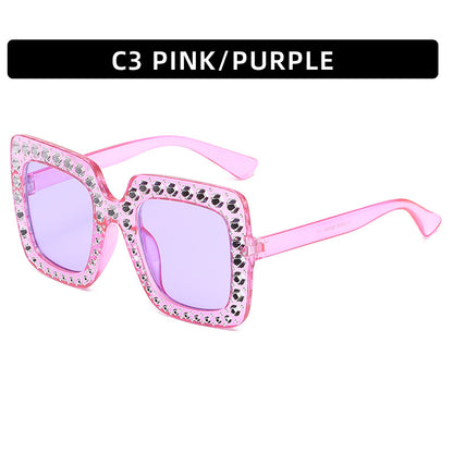 Pink and purple sunglasses with rhinestone accents on a white background