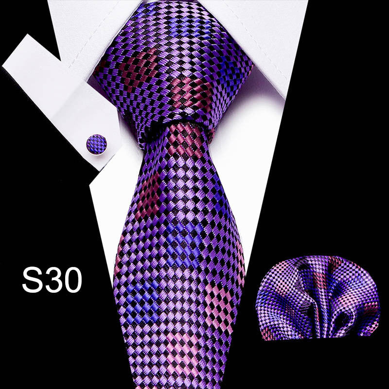 Purple and pink checkered tie set with pocket square and cufflinks on a white background