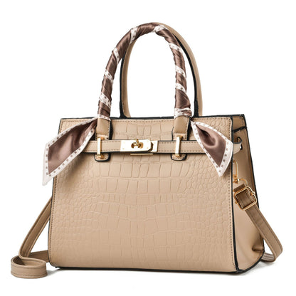 Beige handbag with a decorative ribbon on a white background