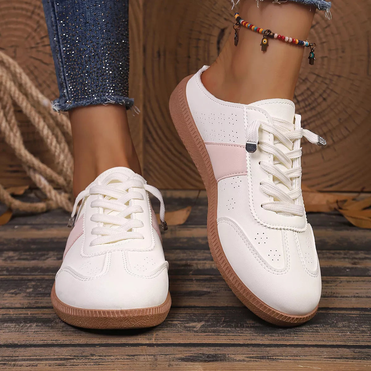White lace-up sneakers with pink side accents, round toe, gum outsole