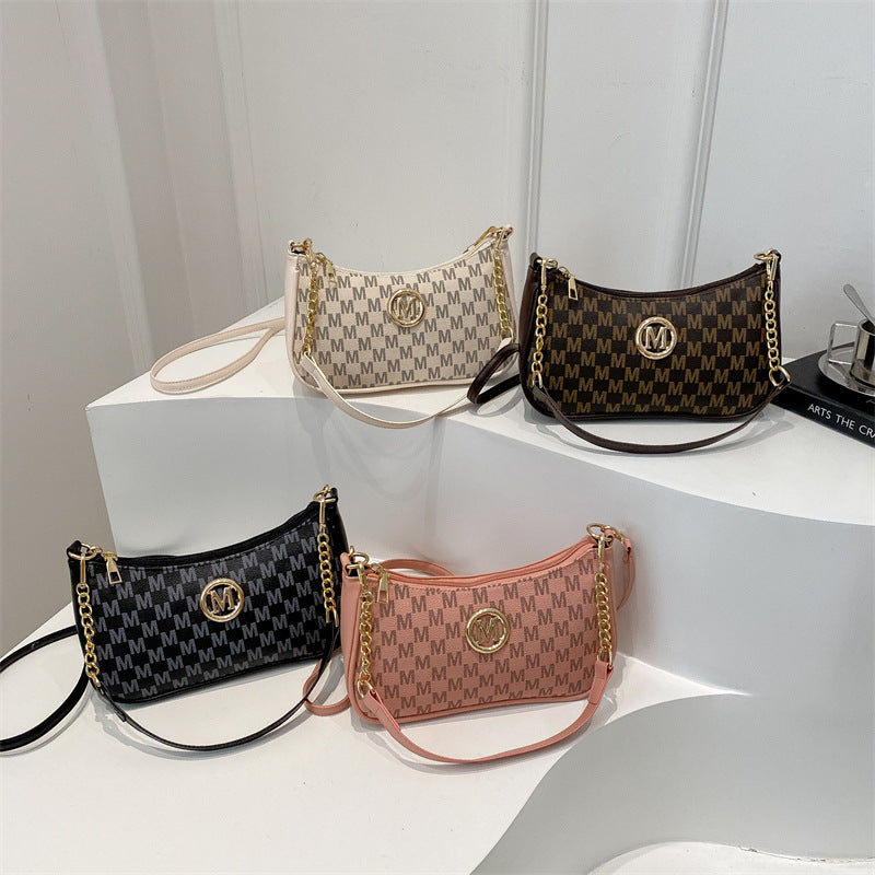 Women’s shoulder pouch bag set with monogram pattern in black, tan, and pink tones