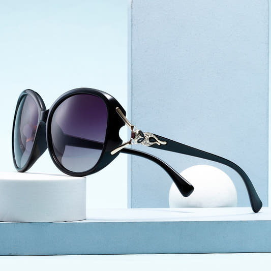 Oversized cat-eye sunglasses, black frame with purple gradient lenses and gold fox detail