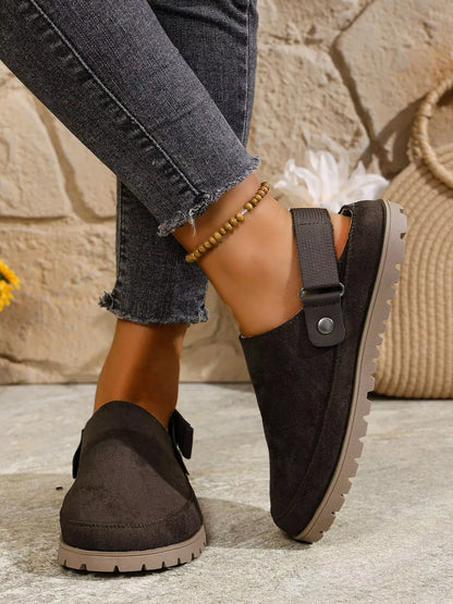 Dark gray round-toe slip-on flats with side strap and low heel tread sole