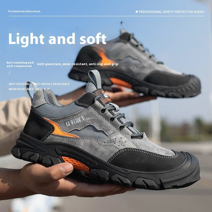 Gray and black safety shoes with orange accents held by a person, against a blurred outdoor background.