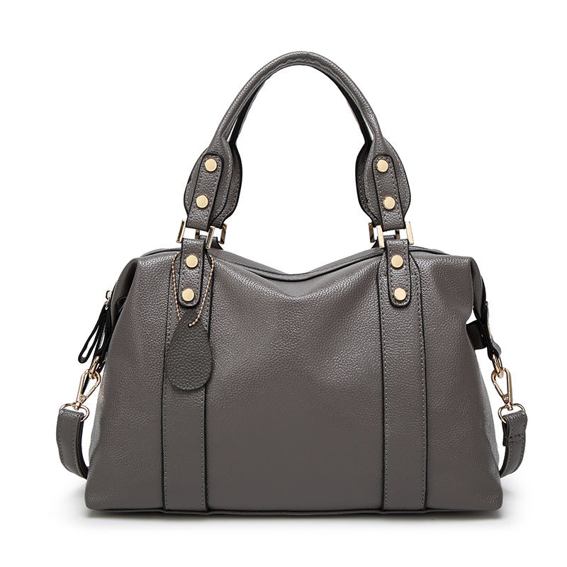 Gray handbag with gold accents on a white background