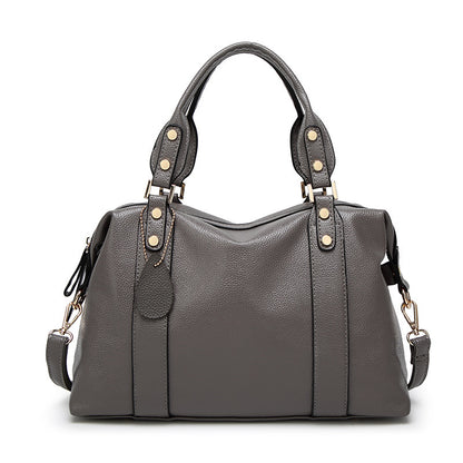 Gray handbag with gold accents on a white background
