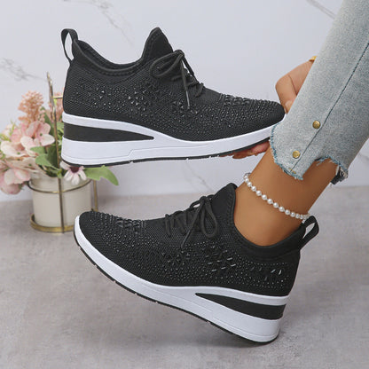Black and white sneakers worn by a person with a light gray background