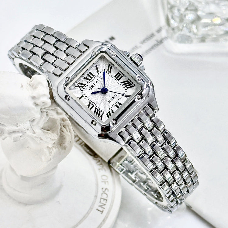 Silver wristwatch with a white face on a white background
