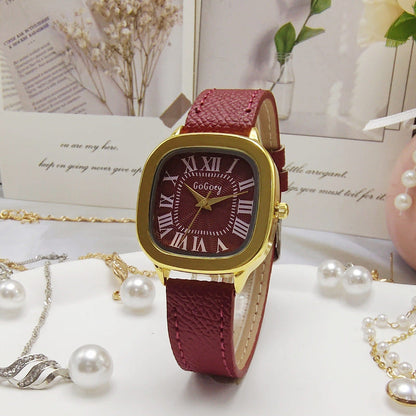 Gold-tone case leather strap watch with Roman numeral dial, burgundy strap