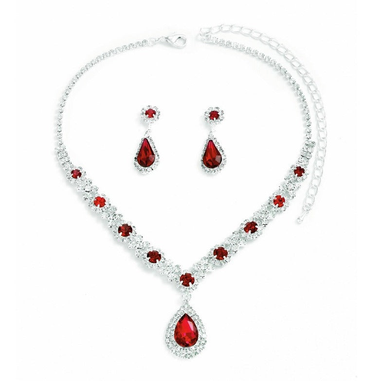 Jewelry set with red teardrop-shaped stones on a white background