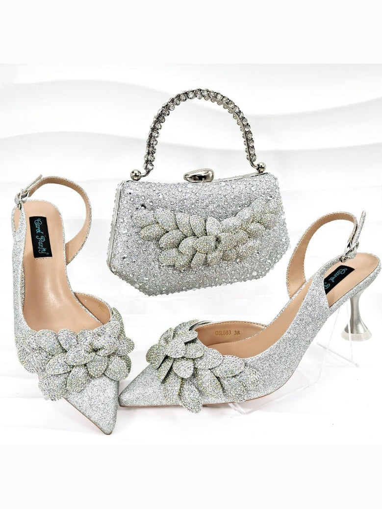 Silver high-heeled shoes with floral designs and a matching handbag on a white background