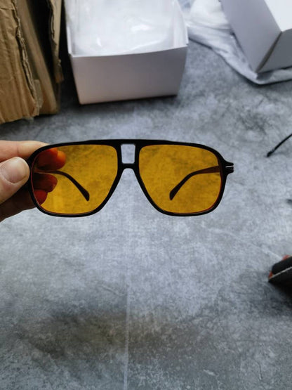 Amber/yellow lens sunglasses with black frame and angular shape