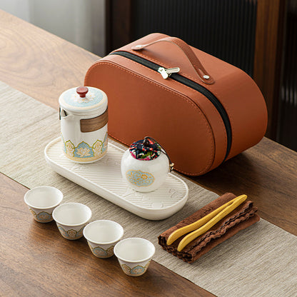 Tea set with ceramic cups, teapot, and accessories on a wooden table.