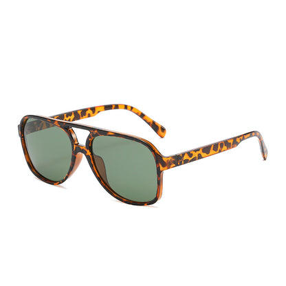 Sunglasses with tortoiseshell frame and green lenses on a white background