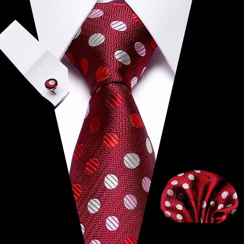 Red patterned tie with matching pocket square and cufflinks on a white background