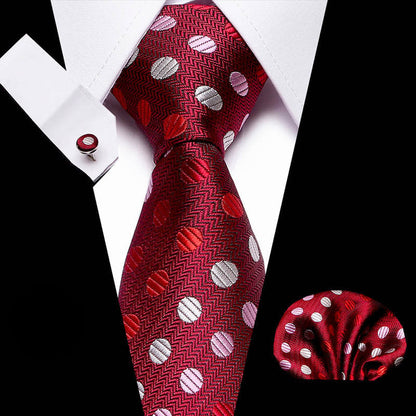 Red patterned tie with matching pocket square and cufflinks on a white background