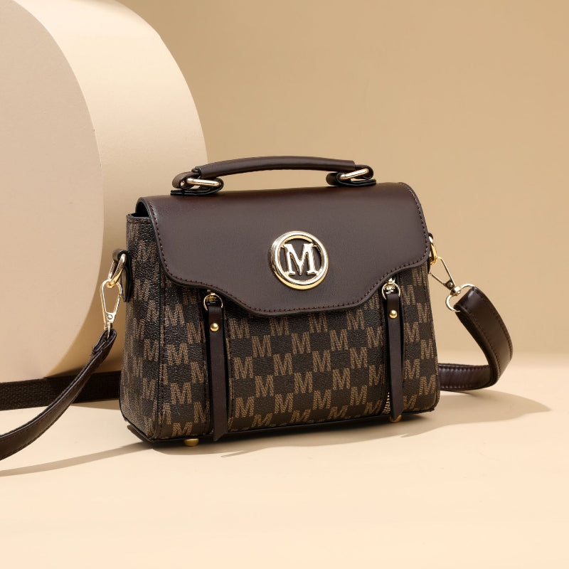 Brown handbag with gold accents and a visible brand logo on a beige background