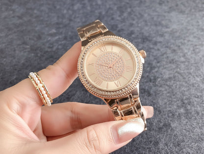 Rose gold watch with diamond accents held by a hand, against a Guess branded box.