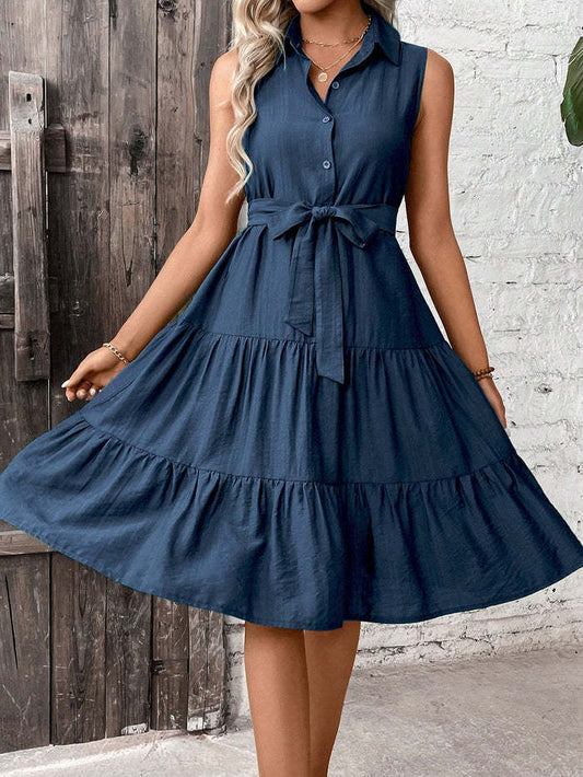 Woman wearing a navy blue dress with a wooden and brick wall background