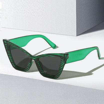 Green sunglasses with a geometric frame on a white background