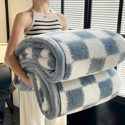 Person holding a folded checkered blanket in a room with windows.