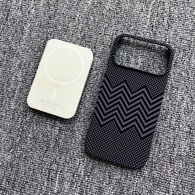 Two phone cases, one white and one black with zigzag pattern, on a textured gray surface.