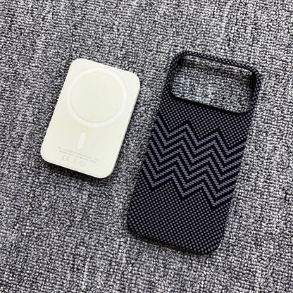 Two phone cases, one white and one black with zigzag pattern, on a textured gray surface.