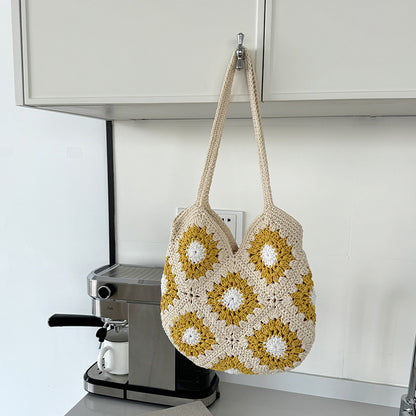 Crocheted bag with floral pattern hanging on a kitchen cabinet