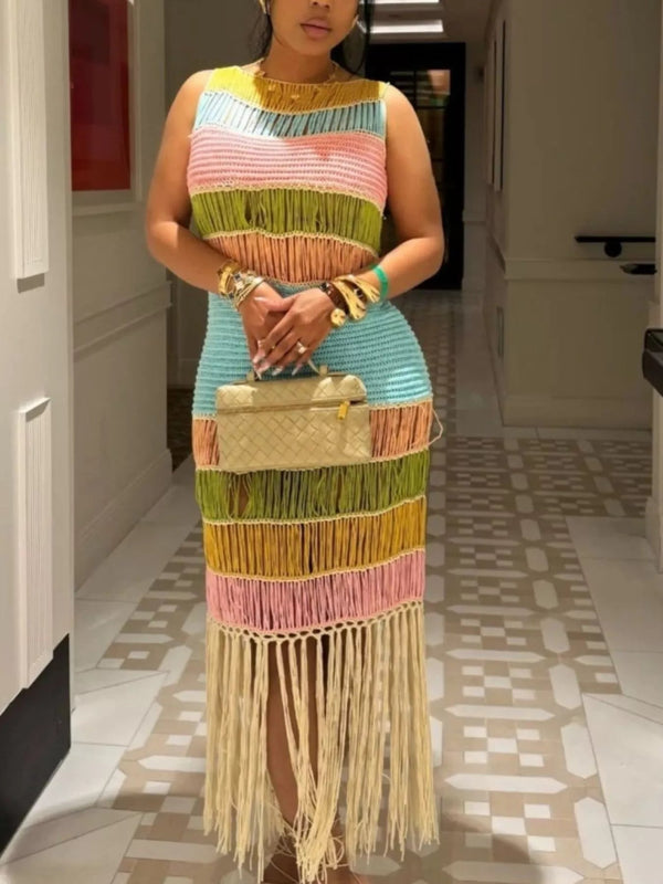 Woman wearing a colorful striped dress with fringe details indoors.
