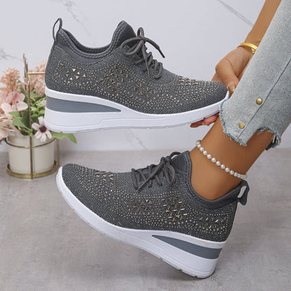 Gray sneakers with white soles worn by a person, with a light background