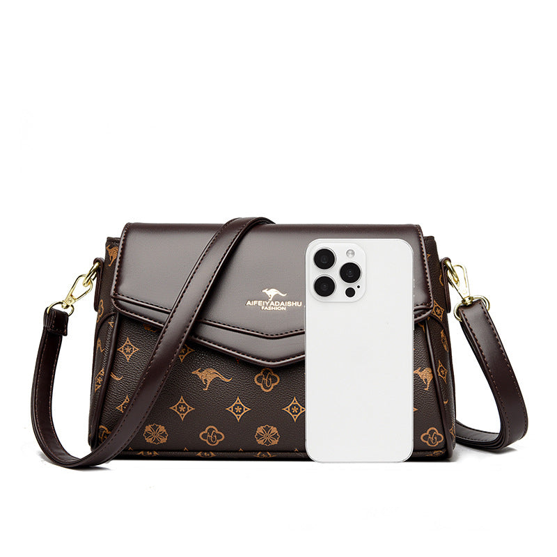Brown patterned handbag with a phone case on a white background