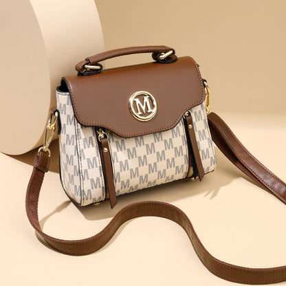 Designer handbag with brown leather top and beige body featuring a logo on a beige background