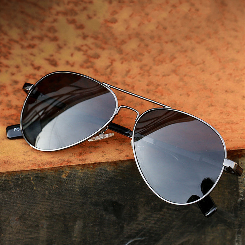Aviator sunglasses with reflective lenses on a wooden surface