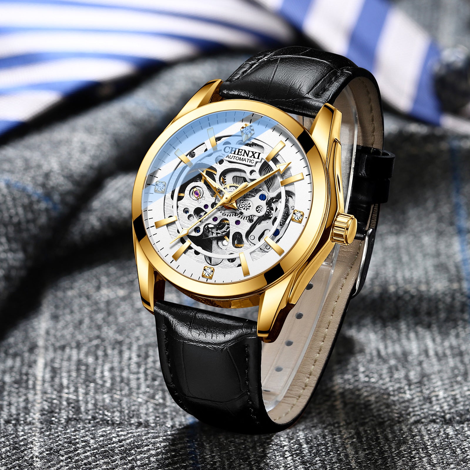 Gold mechanical watch with black leather strap, skeleton dial and crown.