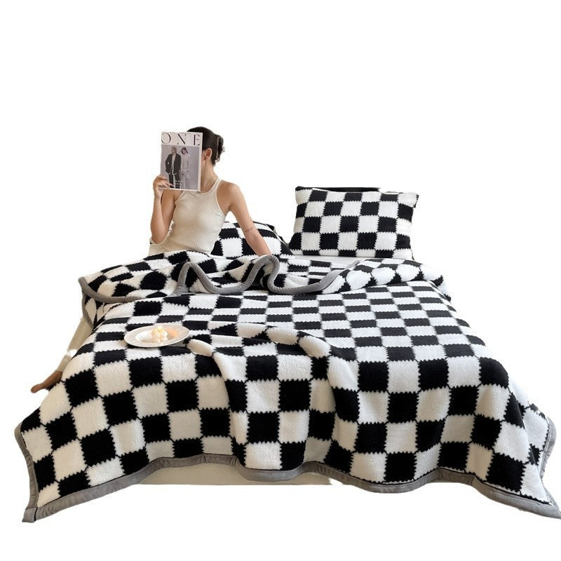 Person sitting on a bed with black and white checkered bedding