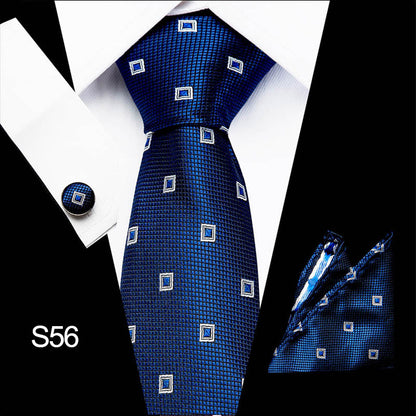 Blue patterned tie with matching pocket square and cufflinks on a white shirt.