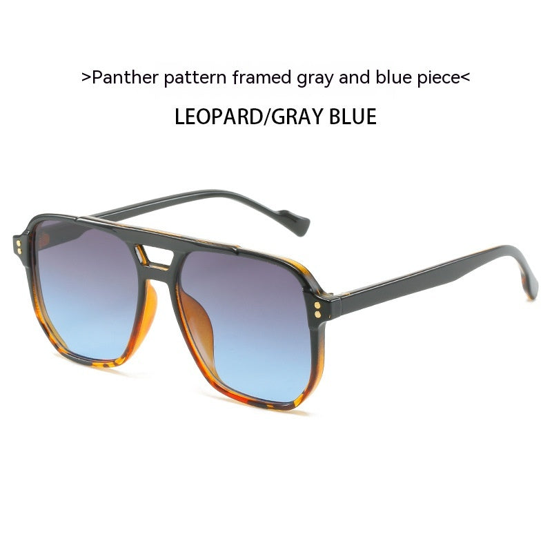 Sunglasses with leopard pattern frame and gray to blue gradient lenses on a white background.