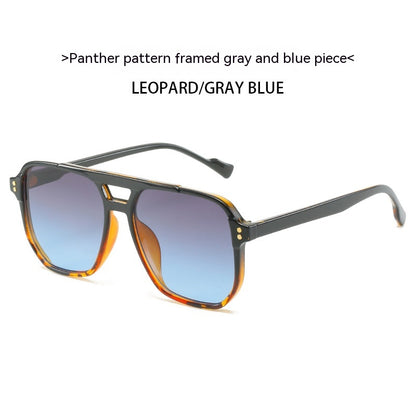 Sunglasses with leopard pattern frame and gray to blue gradient lenses on a white background.