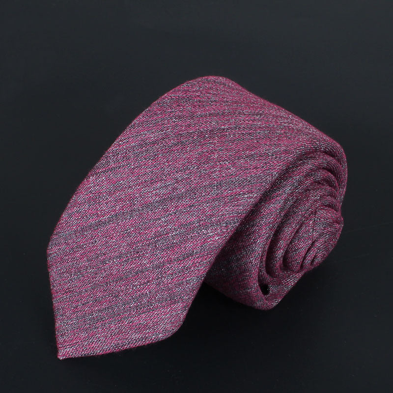 Rolled-up pink and gray tie on a black background