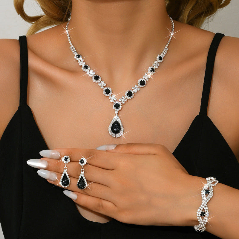 Bridal jewelry set with white crystal necklace, black teardrop pendant, and earrings