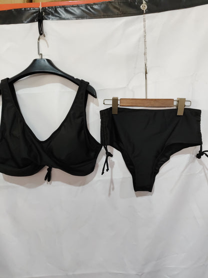 Black bikini top and bottom hanging on a white background